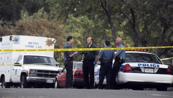 Investigators from the Colorado Springs Police Dept. talk outside the home where a woman and her 13-year-old twins were found dead on Monday.